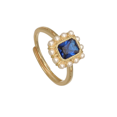A gold-plated adjustable ring featuring a square-cut blue gemstone surrounded by a halo of small white faux pearls.
