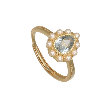 A gold ring featuring a central pear-cut pale green gemstone surrounded by a halo of small white pearls, set on a polished gold band