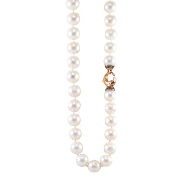 A strand of white cultured pearls with a rose gold and crystal clasp.