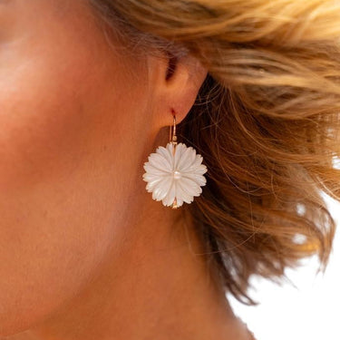 Close-up of a woman wearing a floral earring with a blurred background