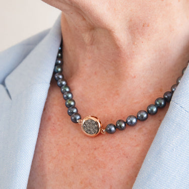 Peacock pearl necklace with a gold and crystal clasp.