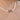 A close-up of a pearl necklace worn on a person's neck, featuring a round rose gold pendant with a central clear gemstone surrounded by small dark stones.