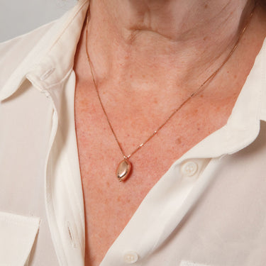 A rose gold nugget drop pendant on a sterling silver chain.